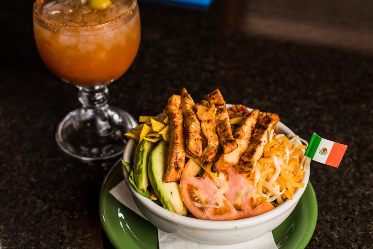 Avocado, tomato, and mozzarella salad with fried chicken on top